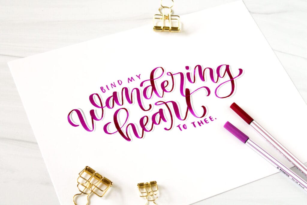 brush pen calligraphy in magenta that says "bind my wandering heart to thee"